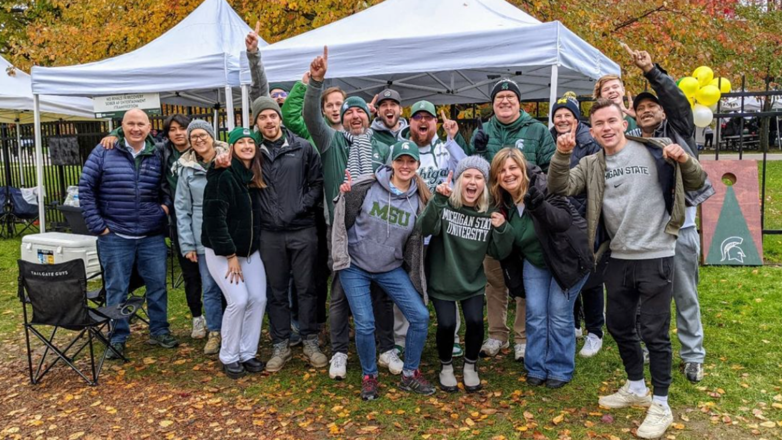 A group of students, staff and alumni enjoying a sober tailgate on a fall day.