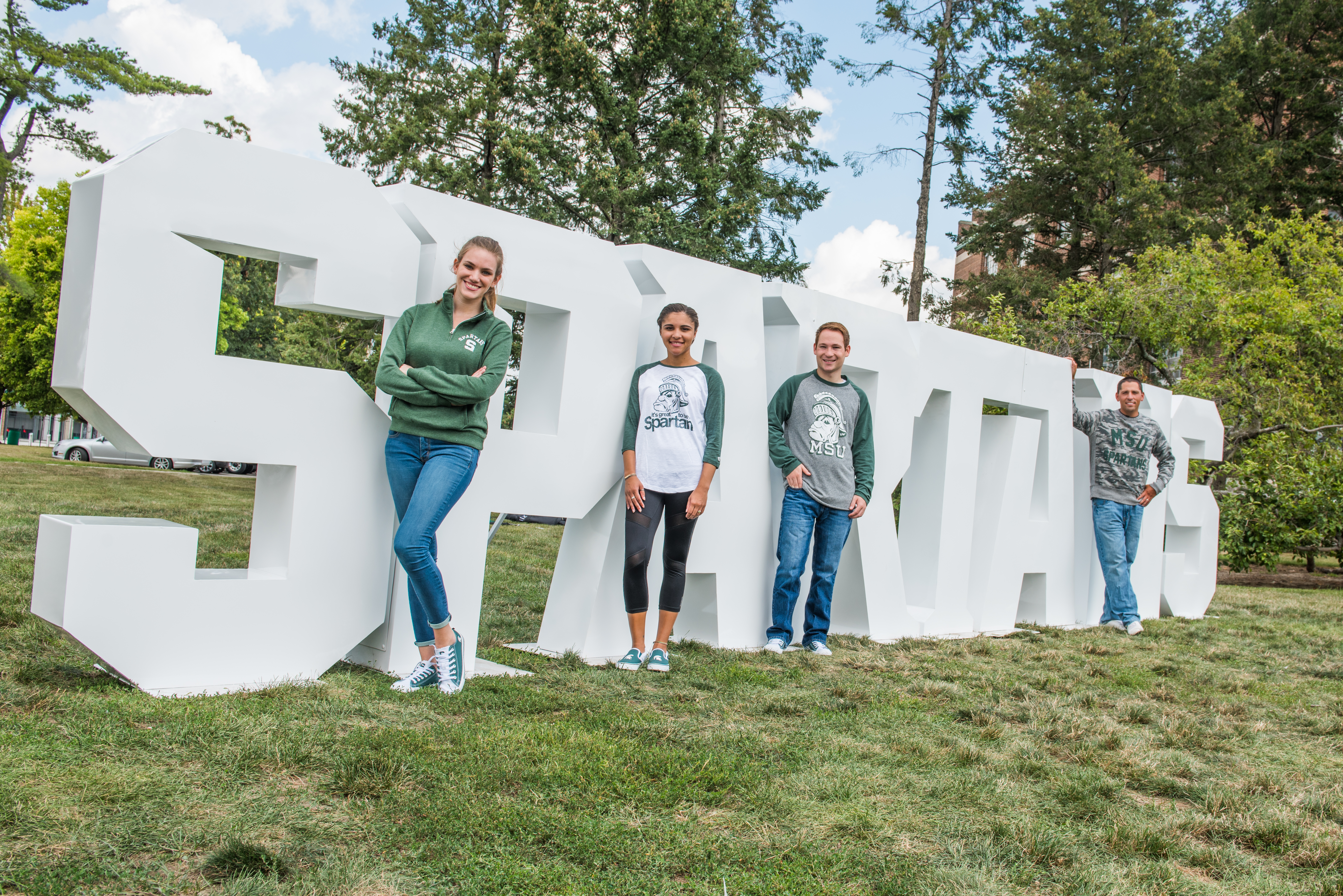 students in front of spartan sign